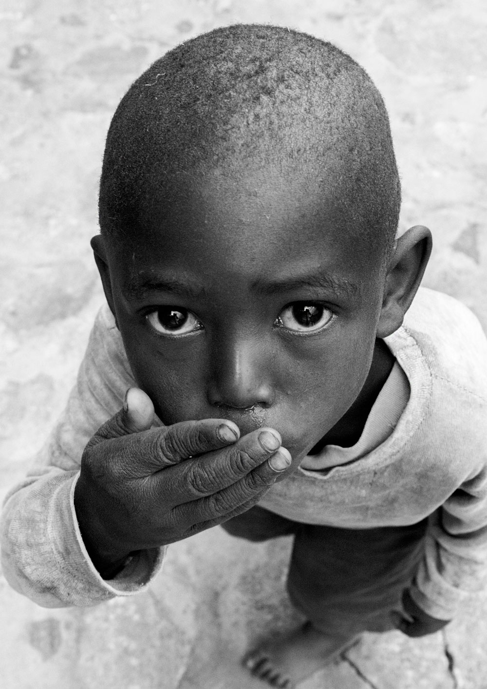 Black and white photogrpahy with the title 'Africa V'. A portrait of a little boy looking up to the camera. From the series 'Children of Tanzania'.