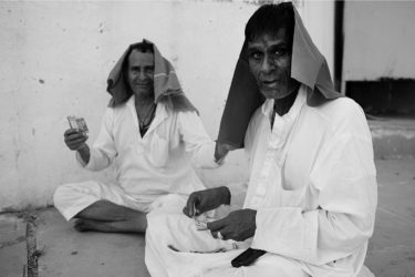 Black and White photography with the title 'India 24'. Portrait of two traditionally dressed Indian men sitting on the floor.